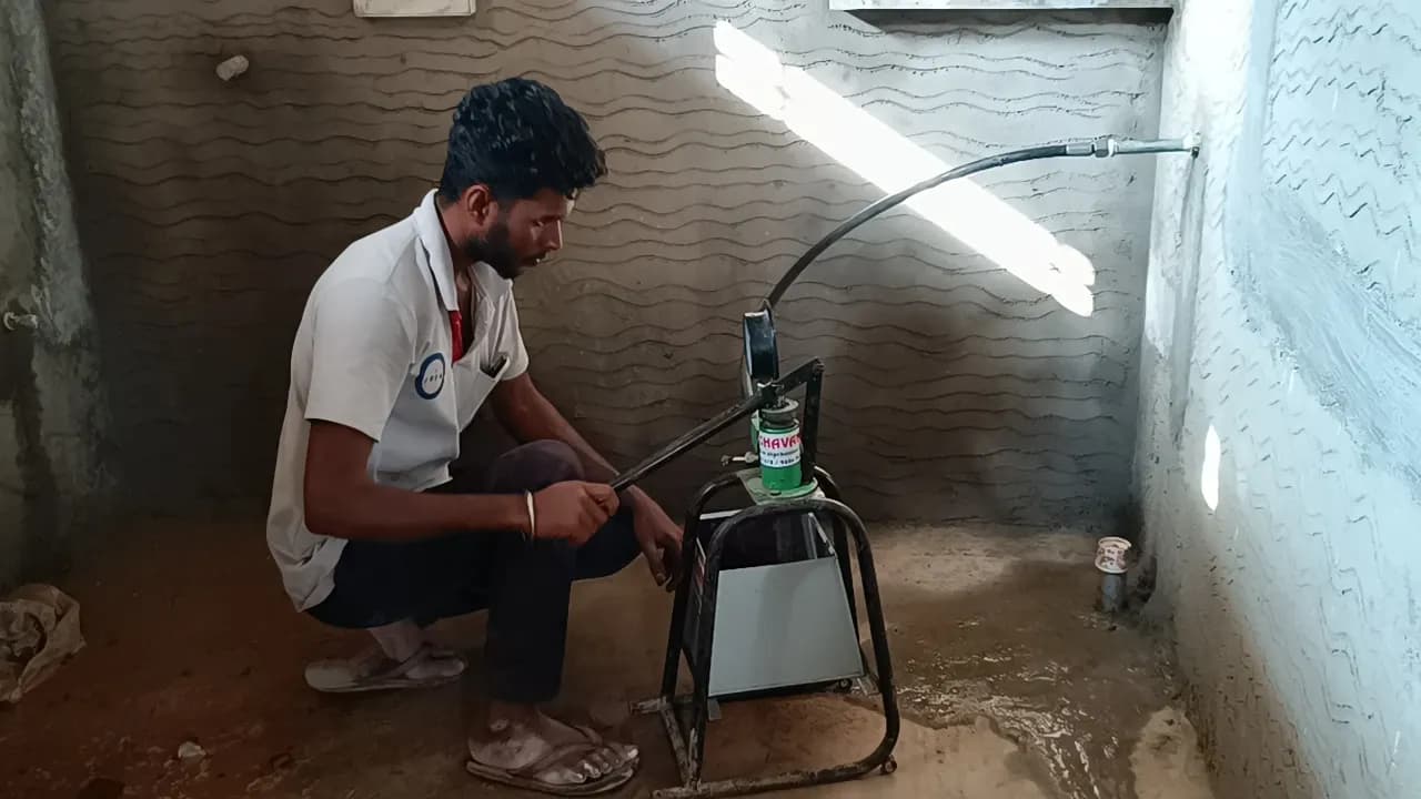 ESEA technician pressure testing a plumbing line with a hand pump